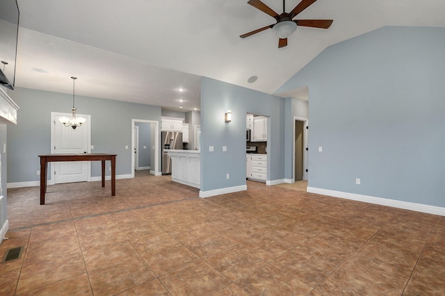 unfurnished living room with high vaulted ceiling, ceiling fan with notable chandelier, and tile patterned floors