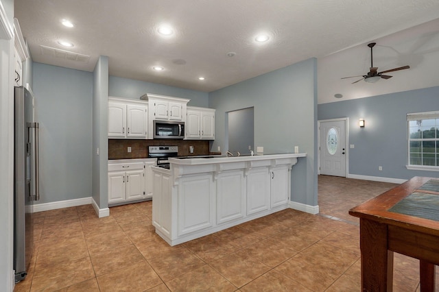 kitchen featuring white cabinetry, light tile patterned floors, decorative backsplash, and stainless steel appliances