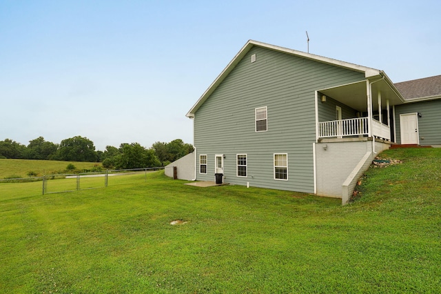 rear view of house featuring a yard