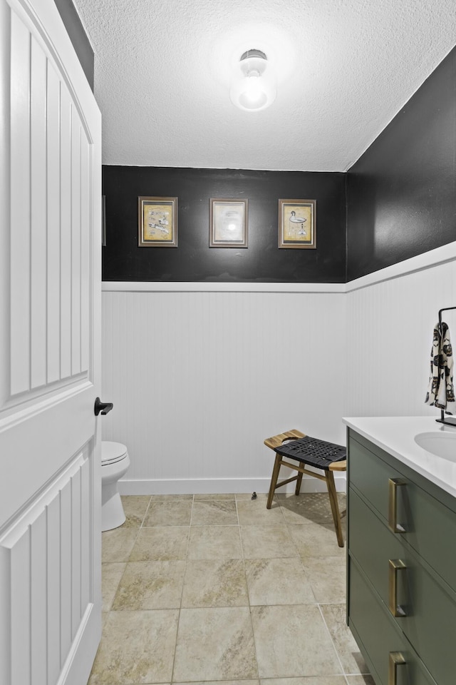 bathroom featuring vanity, tile patterned floors, toilet, and a textured ceiling