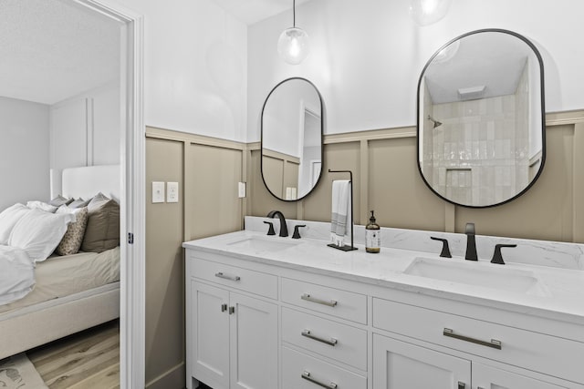 bathroom with wood-type flooring, vanity, and walk in shower