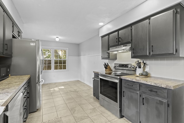 kitchen with backsplash, stainless steel appliances, and light tile patterned flooring