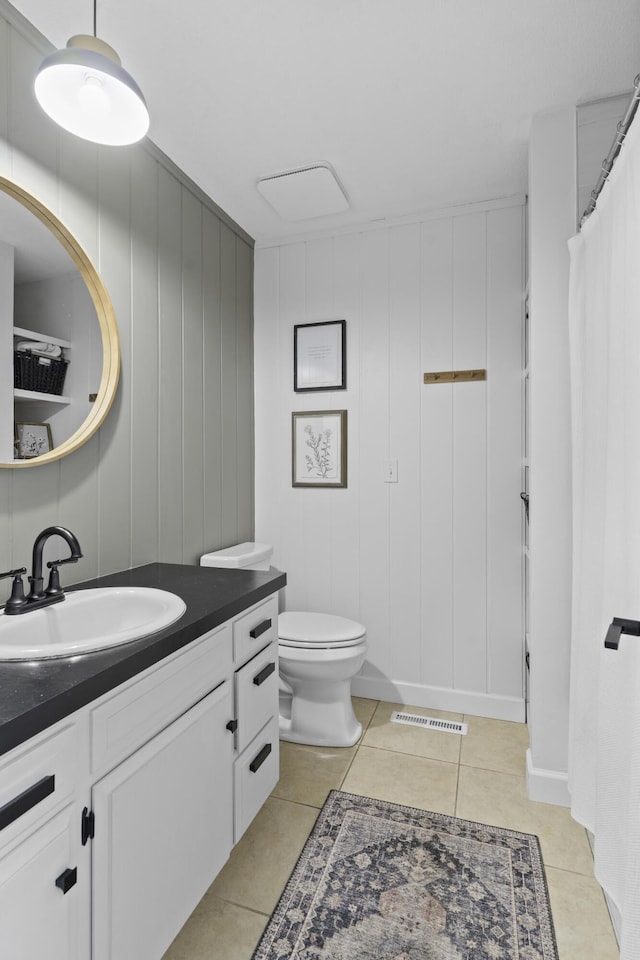 bathroom featuring vanity, tile patterned floors, and toilet