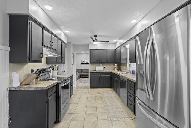 kitchen featuring light tile patterned flooring, appliances with stainless steel finishes, sink, decorative backsplash, and ceiling fan