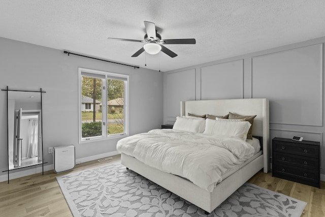 bedroom featuring ceiling fan, a textured ceiling, and light hardwood / wood-style flooring