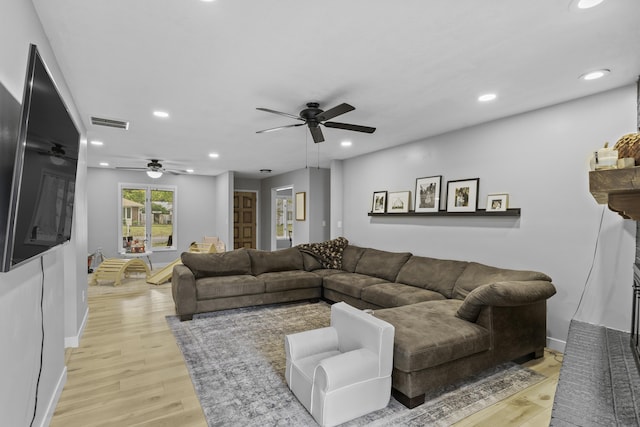 living room featuring ceiling fan and light wood-type flooring