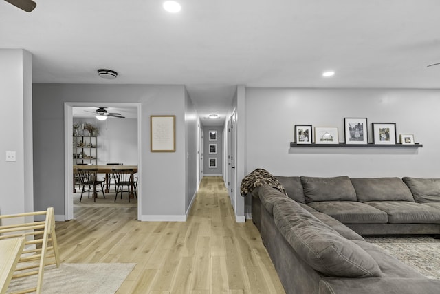 living room featuring ceiling fan and light wood-type flooring