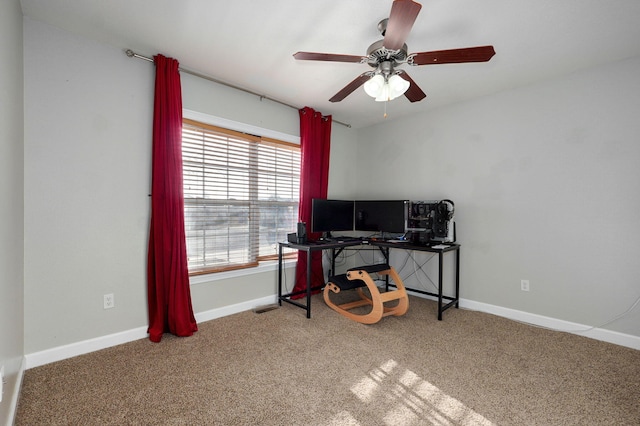 carpeted office space featuring ceiling fan