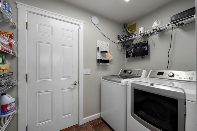 clothes washing area with dark tile patterned flooring and washer and dryer