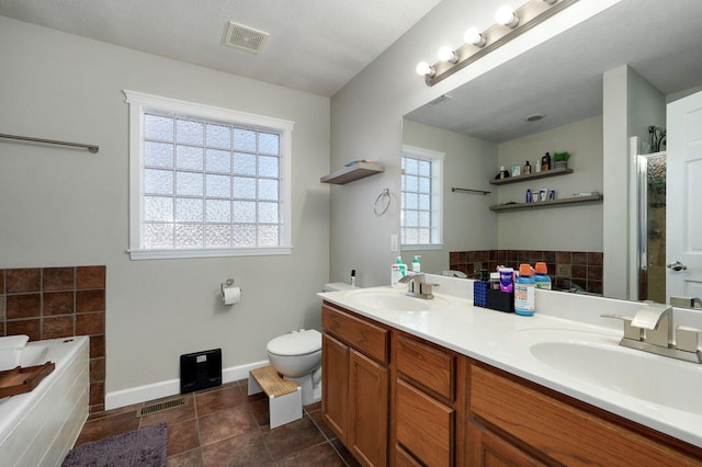 bathroom featuring vanity, tile patterned floors, toilet, and a bathing tub