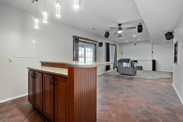 kitchen with ceiling fan, decorative light fixtures, and a center island