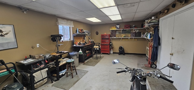 interior space featuring a workshop area and a drop ceiling