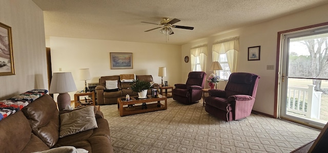 carpeted living room with ceiling fan and a textured ceiling