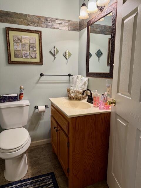 bathroom with tile patterned flooring, vanity, and toilet