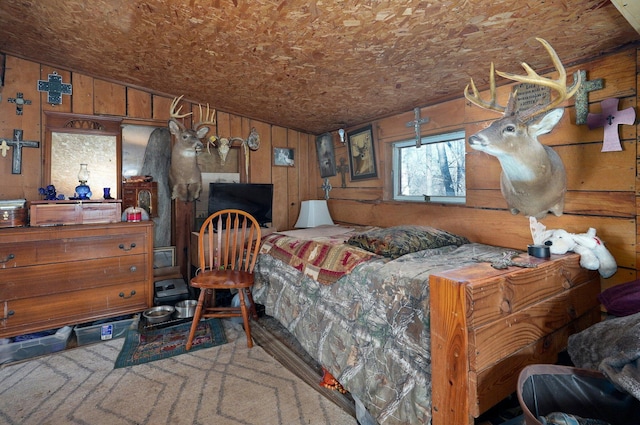 bedroom featuring lofted ceiling, a fireplace, and wooden walls