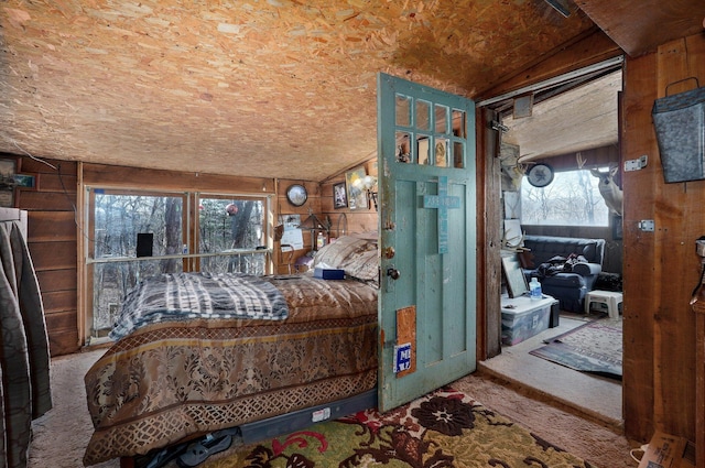 bedroom featuring lofted ceiling and wood walls