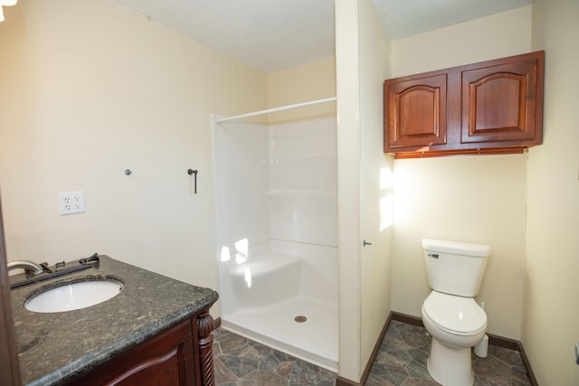 bathroom with vanity, toilet, and a shower