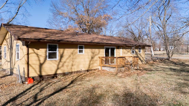 view of side of home featuring a wooden deck and a lawn