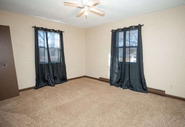 unfurnished room featuring a baseboard radiator, carpet, a textured ceiling, and ceiling fan