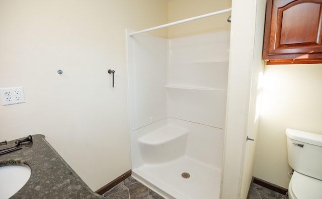 bathroom featuring walk in shower, toilet, and sink