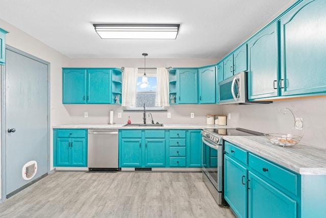 kitchen with decorative light fixtures, blue cabinets, sink, stainless steel appliances, and light wood-type flooring