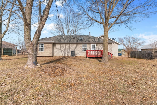 back of house with a wooden deck and a lawn