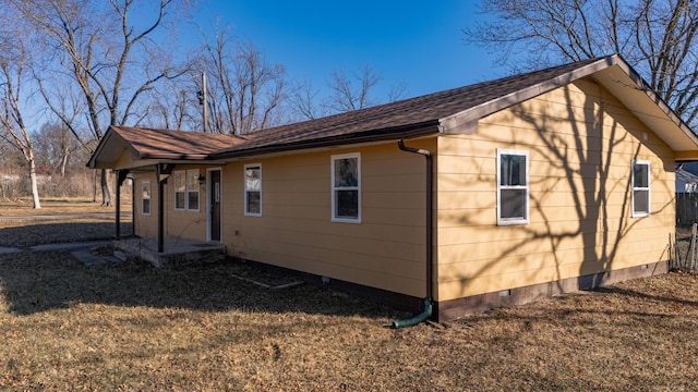 view of side of home with a yard