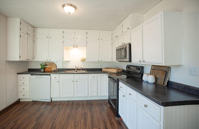 kitchen with dark hardwood / wood-style floors, dishwasher, sink, white cabinets, and black electric range