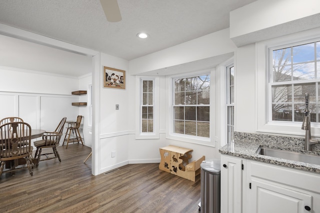 dining space featuring ceiling fan, dark hardwood / wood-style floors, sink, and a textured ceiling