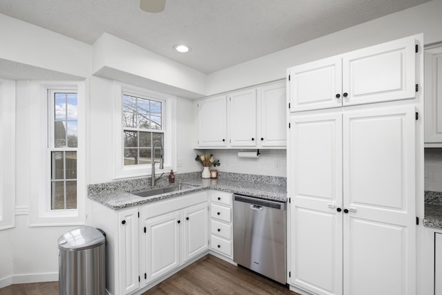 kitchen with sink, dishwasher, white cabinetry, dark hardwood / wood-style floors, and light stone counters