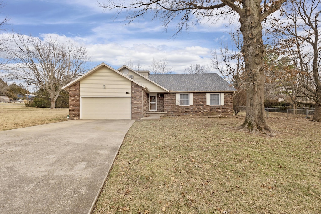 ranch-style home with a garage and a front yard