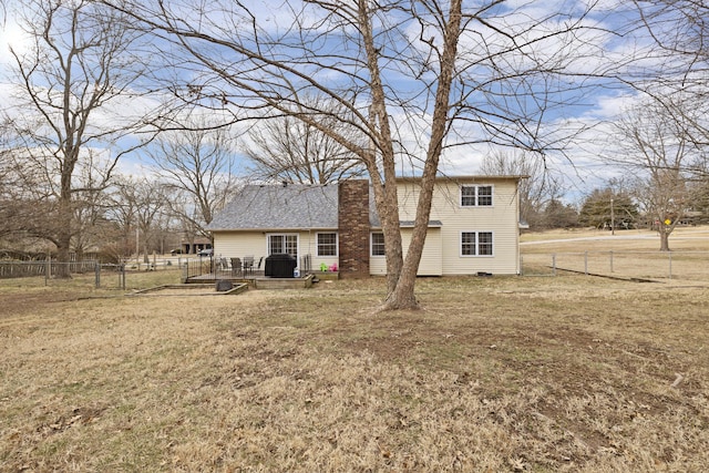 rear view of property featuring a deck and a lawn