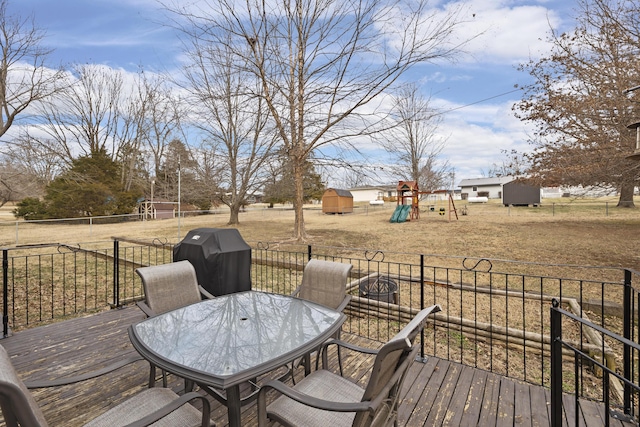 wooden terrace featuring a playground and area for grilling