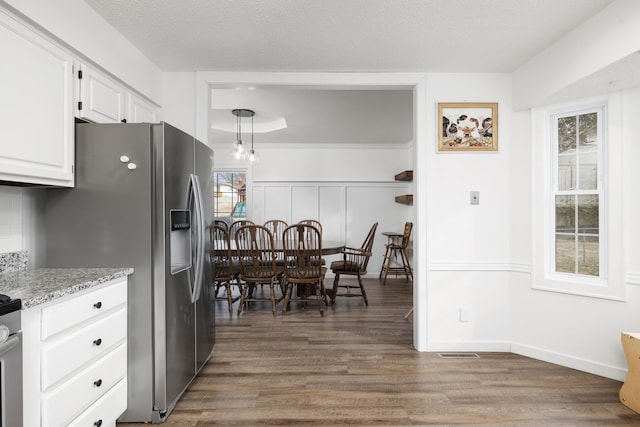 kitchen with decorative light fixtures, backsplash, white cabinets, dark wood-type flooring, and a textured ceiling