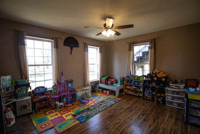 recreation room featuring plenty of natural light, dark wood-type flooring, and ceiling fan