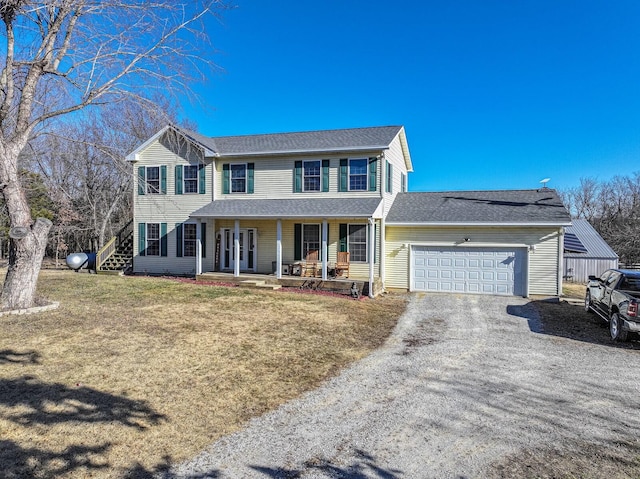 colonial home with a garage, a front yard, and covered porch