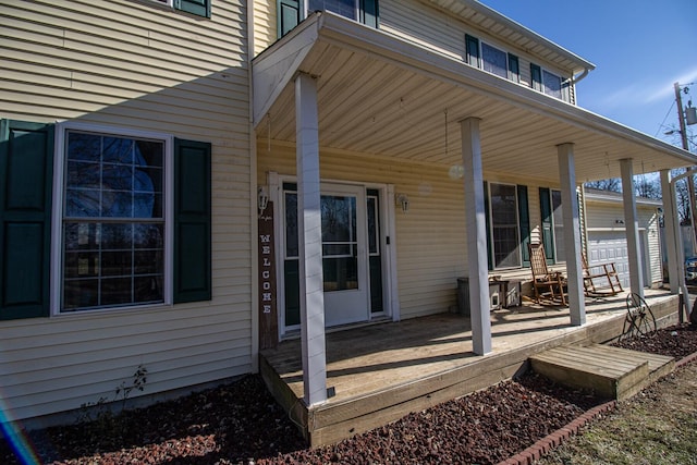 doorway to property with a garage and covered porch