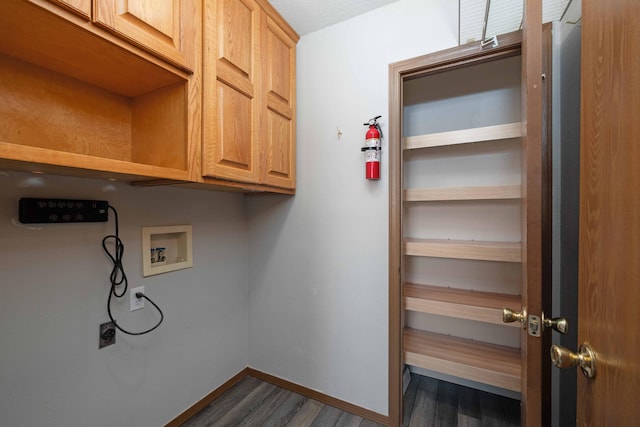 laundry room featuring dark wood-type flooring, cabinets, hookup for a washing machine, and electric dryer hookup