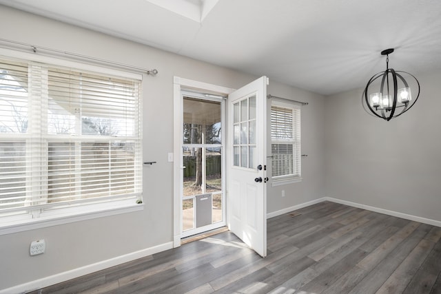 entryway featuring dark wood-type flooring and a notable chandelier