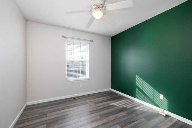 unfurnished room featuring dark wood-type flooring and ceiling fan