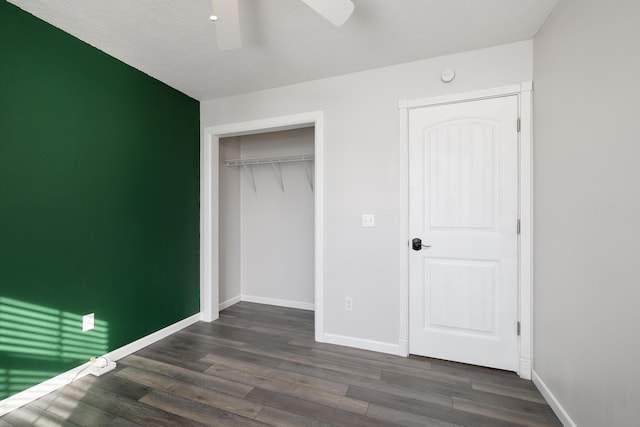 unfurnished bedroom featuring dark wood-type flooring, ceiling fan, and a closet