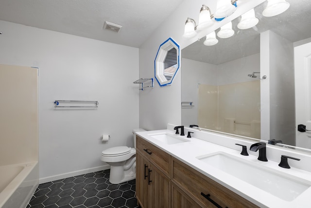 full bathroom with washtub / shower combination, vanity, a textured ceiling, tile patterned floors, and toilet