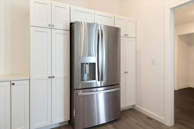 kitchen featuring stainless steel refrigerator with ice dispenser, dark wood-type flooring, and white cabinets