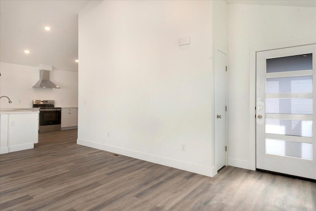 unfurnished living room with dark wood-type flooring, vaulted ceiling, and sink