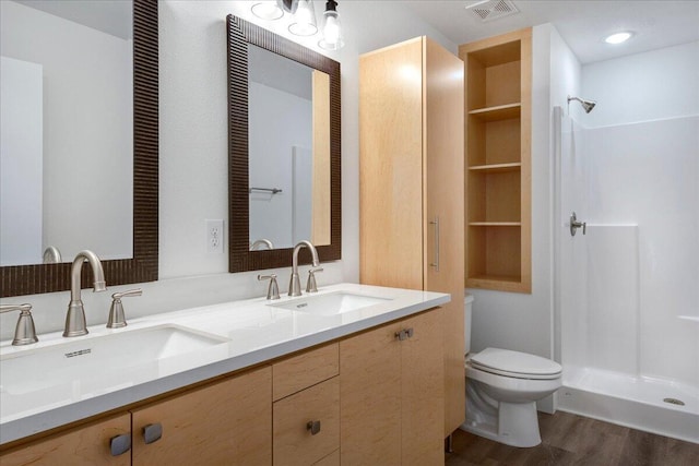 bathroom featuring vanity, hardwood / wood-style floors, toilet, and walk in shower