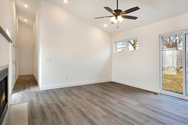 unfurnished living room with lofted ceiling, dark wood-type flooring, and ceiling fan