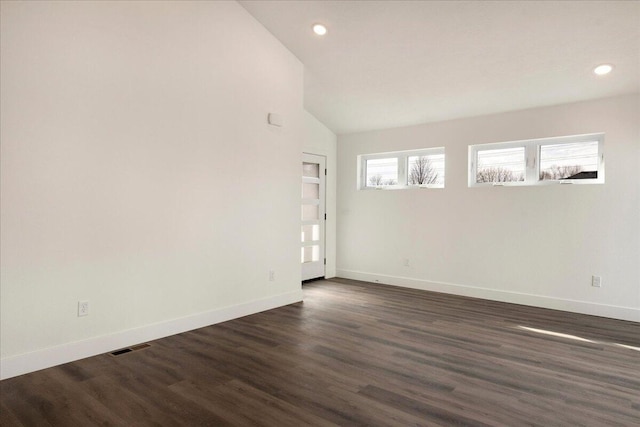 spare room with lofted ceiling and dark hardwood / wood-style flooring