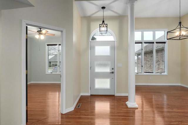 foyer entrance featuring wood-type flooring, ceiling fan, and ornate columns