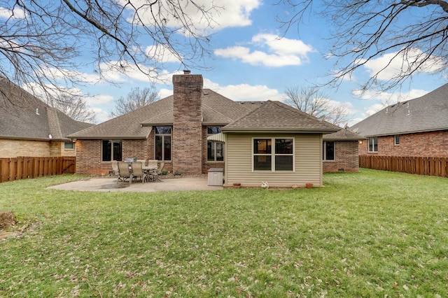 rear view of house with a patio area and a lawn