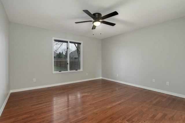 empty room featuring dark wood-type flooring and ceiling fan